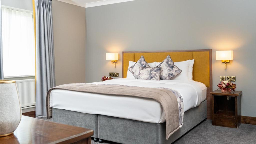 a bedroom with a large white bed with two pillows at Cavan Crystal Hotel in Cavan