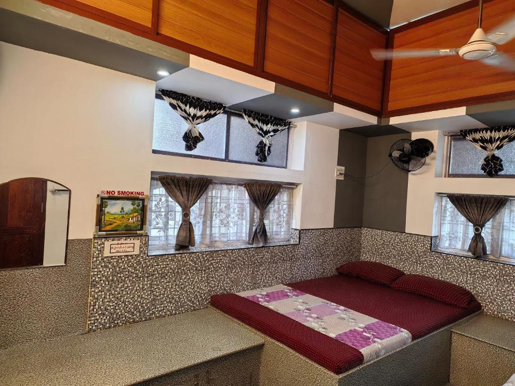 a room with a bed and some windows at Clintons Cove in Cochin