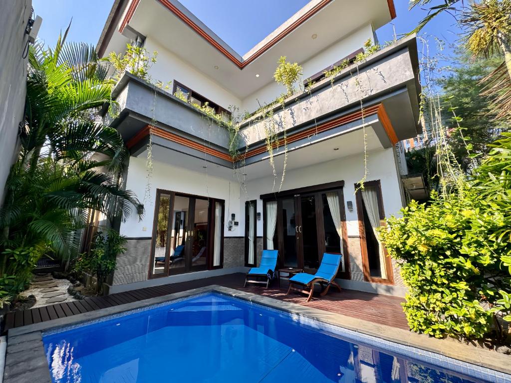 a villa with a swimming pool and a house at Ramantika Sunset Bay in Nusa Dua