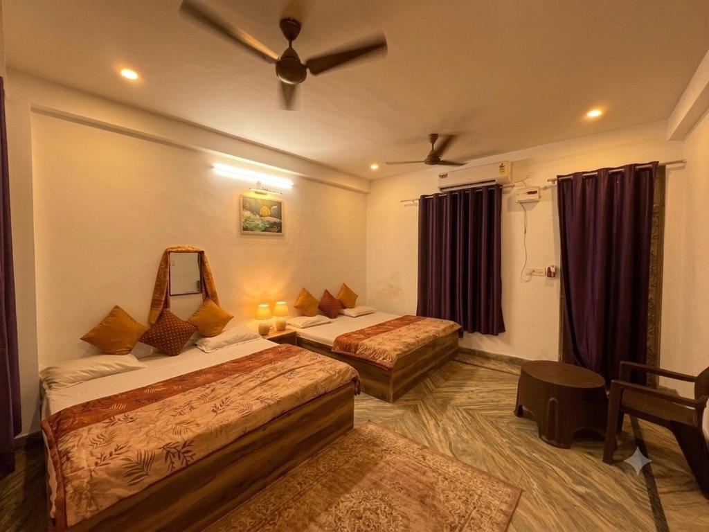 a hotel room with two beds and a mirror at Annapurna Homestays in Varanasi