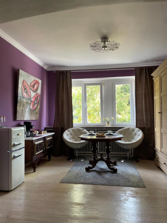 a purple room with a table and two chairs at Gemütlicher Oase mit eigenen Bad in Zentrale, jedoch ruhige Lage in Mönchengladbach