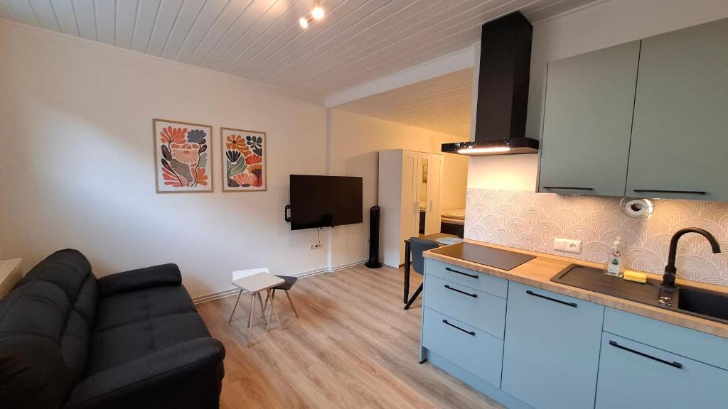 a living room with a couch and a kitchen at Apartment 2 Unter den Eichen in Tätendorf-Eppensen