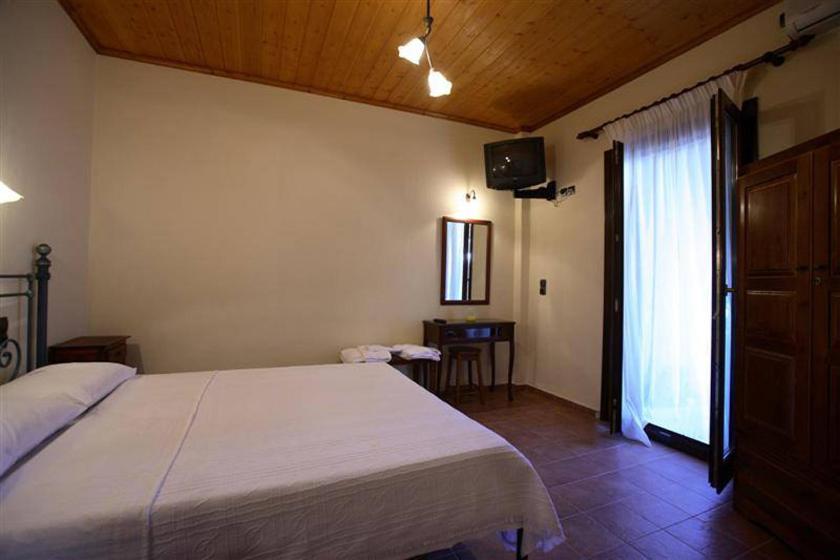 ルートラキにあるMirsinia Apartments - Skopelosのベッドルーム(大きな白いベッド1台、テレビ付)
