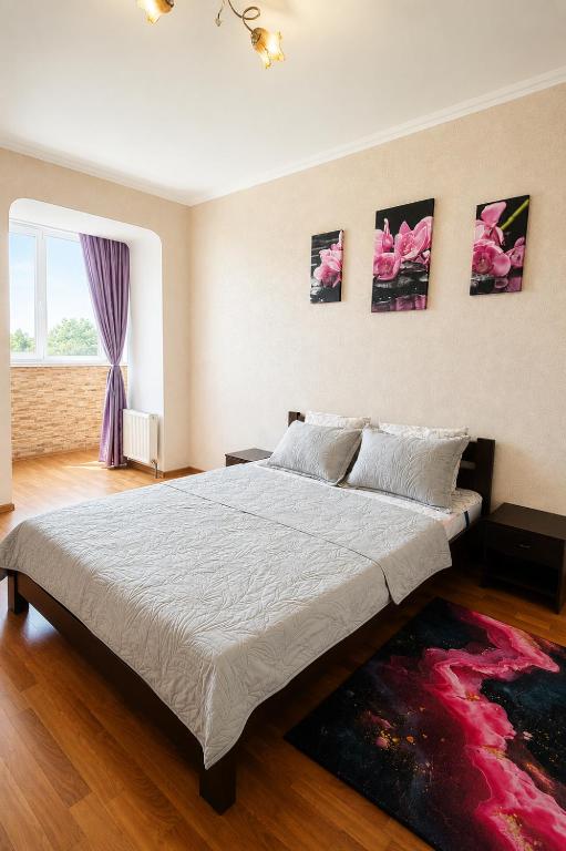 a bedroom with a large bed and a window at Apartment Ekaterina in Chornomorsk