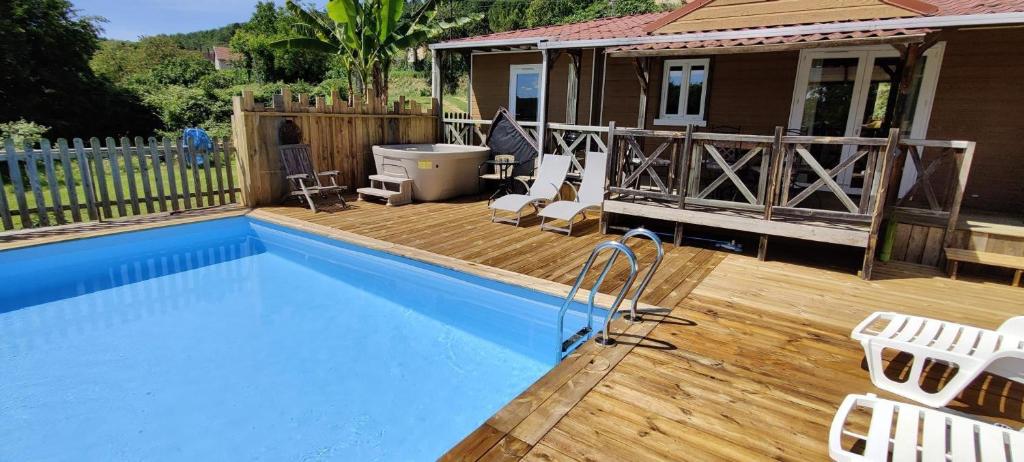 a swimming pool with a deck and a house at Gite De Baunac in Aubas