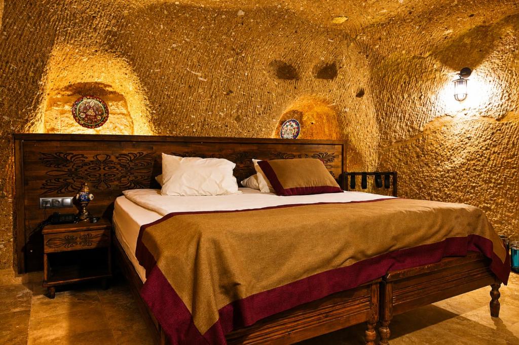 a bedroom with a bed in a stone room at la mar cave cappadocia in Ürgüp
