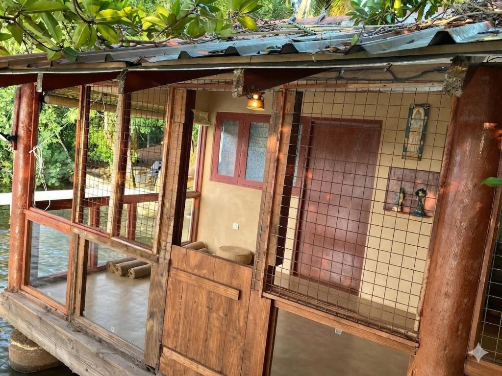 a building with a cage in the water at Yasindu Riverfront Villa in Balapitiya