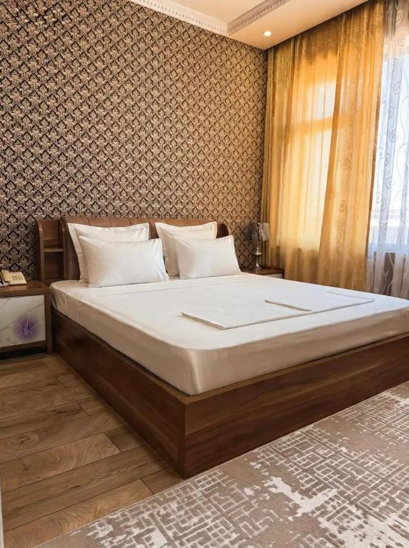 a bedroom with a large bed in a room at Seoul Hotel in Shymkent