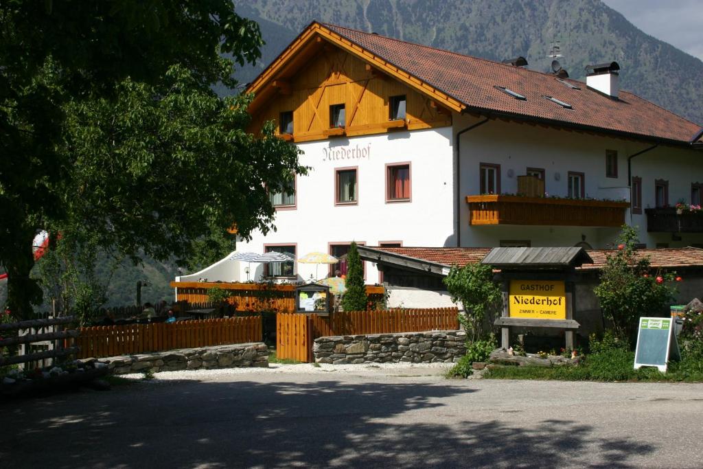 un gran edificio blanco con una valla delante en Niederhof, en Parcines