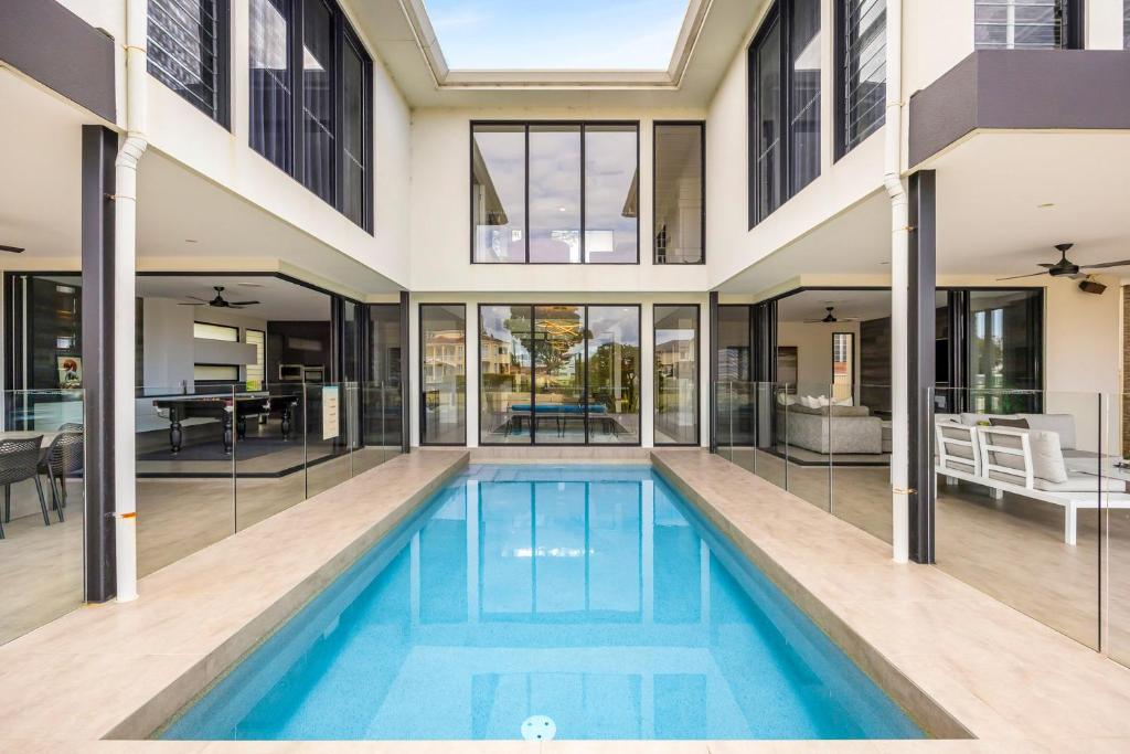 an indoor pool in a house with glass walls at Bluewater Oasis - Stay 4 Pay 3 in Gold Coast