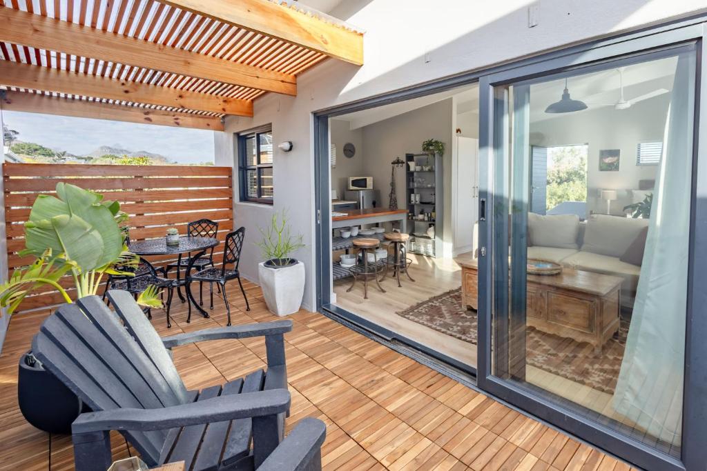 a living room with sliding glass doors and a dining room at Chapmans Corner Studio in Noordhoek