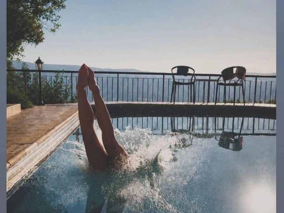 a person laying in the water in a swimming pool at Ithaki House in Lyso
