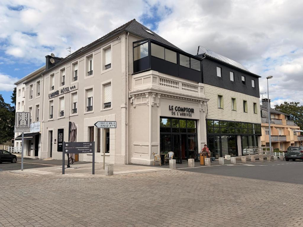 a large white building on the corner of a street at Brit Hotel L'Arrivée Guingamp in Guingamp