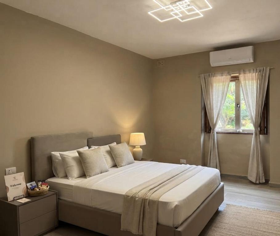 a bedroom with a large bed and a window at Three Cities Haven in Taʼ Penza
