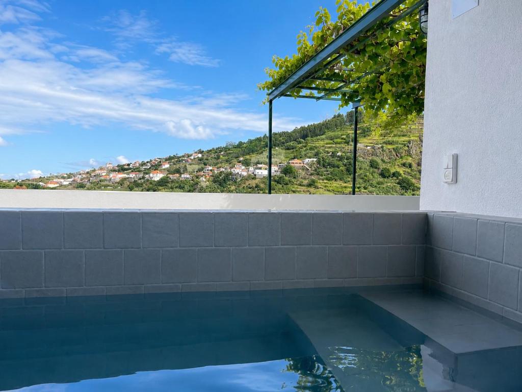 a swimming pool with a view of a mountain at Calheta Suites - Vinha & Jardim - Adults-only suites met hottub & zeezicht in Calheta