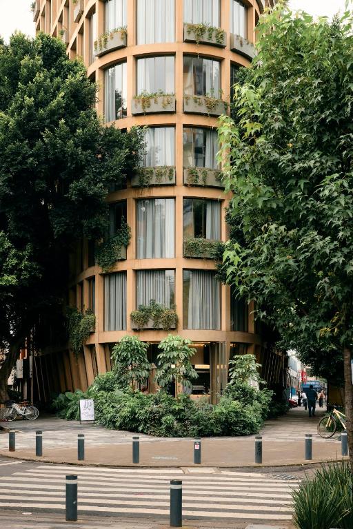 a tall building with trees in front of it at ONTO Tonalá Mexico City in Mexico City