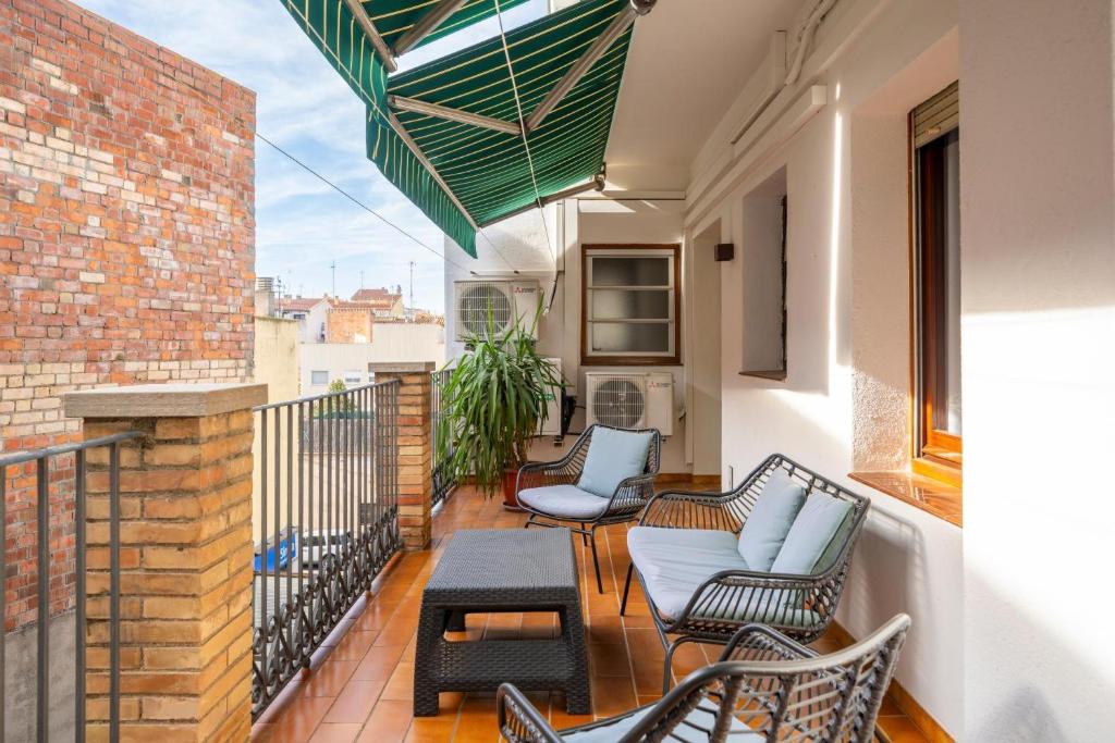 a balcony with chairs and tables on a building at Classic Can Jeroni in Figueres