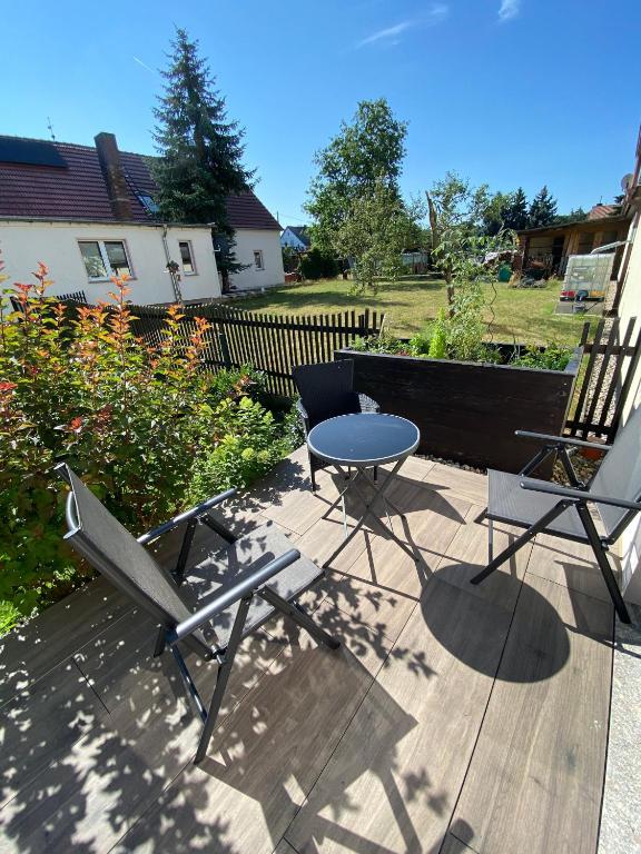 two chairs and a table on a wooden deck at Ferienwohnung "Auszeit" in Dobra