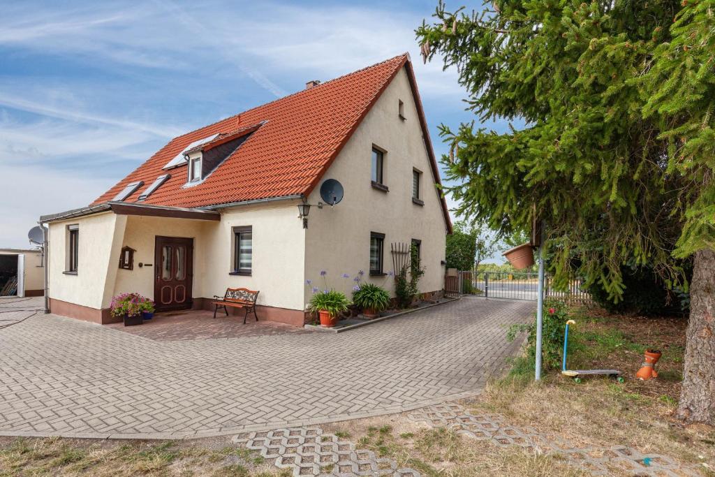 a small white house with an orange roof at Andrea Vacation Home in Döbeln