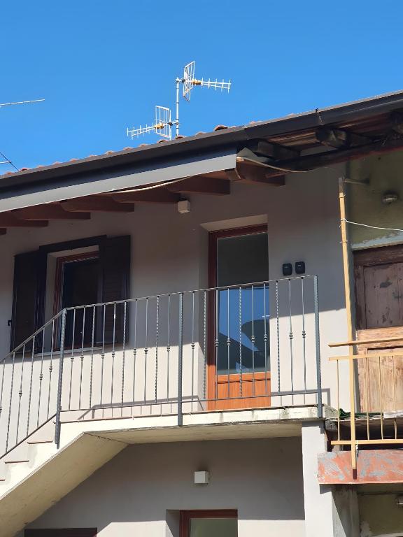 a balcony of a house with an orange door at La Cà de' mi Vecc in Fino Mornasco