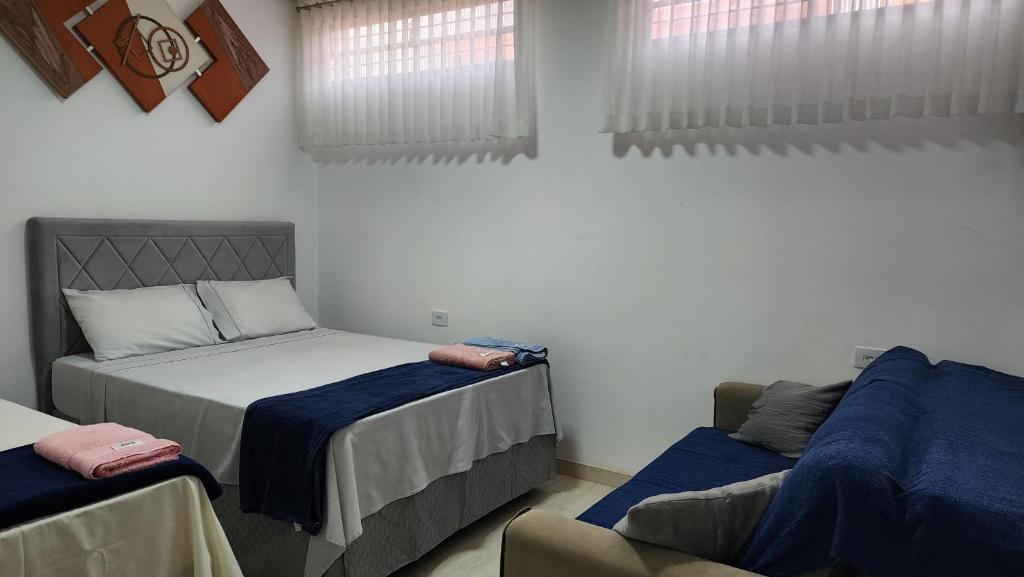a bedroom with two beds and a couch at Casa requinte estilo Ap próx Fema Unesp in Assis
