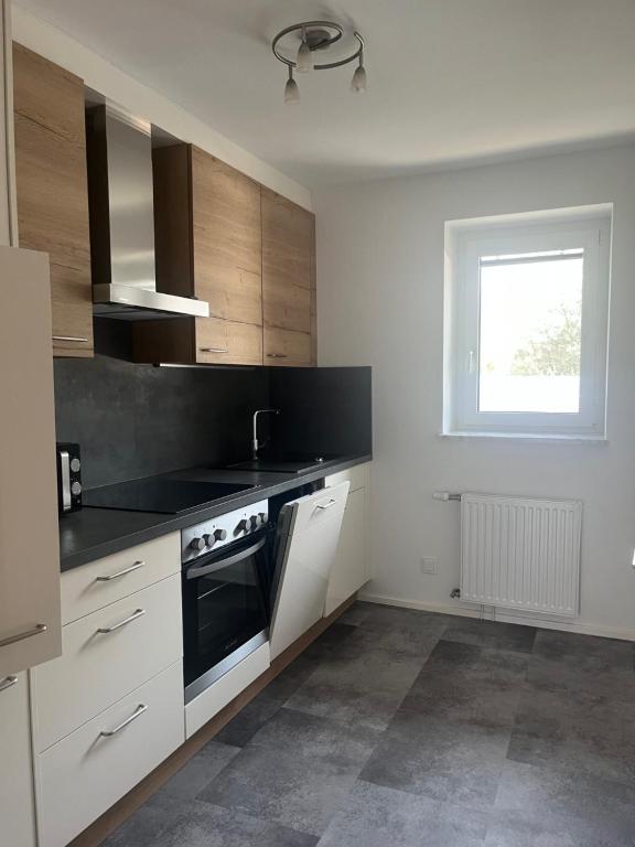 a kitchen with white cabinets and black counter tops at Appartement Kochen in Döbriach