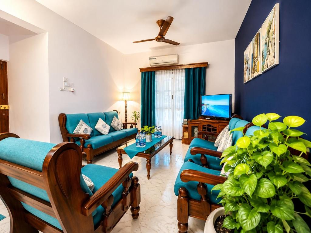 a living room with blue walls and a blue couch at Luxury Stays By The Beach Goa in Benaulim