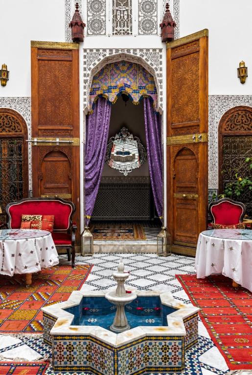 a room with a fountain in the middle of a building at Riad Arabella Fès in Fez
