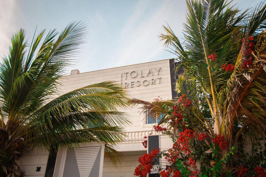 a hotel sign on the side of a building with palm trees at فيلا تولاي in Dahaban
