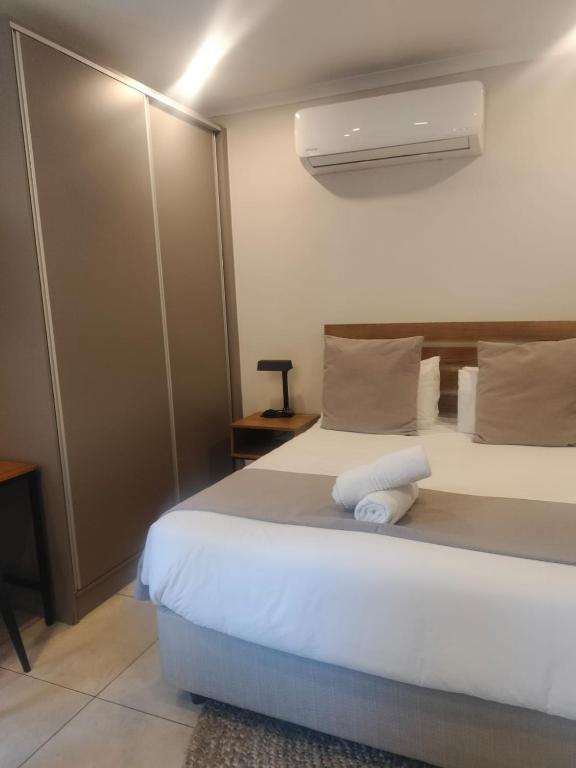 a bedroom with a large white bed with a fan at BlackBrick2 in Johannesburg