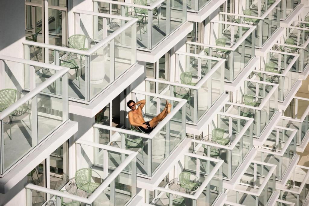 a man sitting on the window of a tall building at Arlo Wynwood Miami in Miami