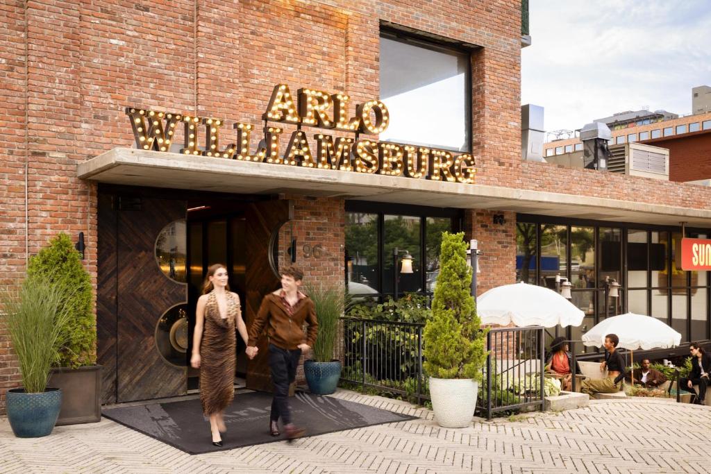 two people walking out of an entrance to a restaurant at Arlo Williamsburg in Brooklyn
