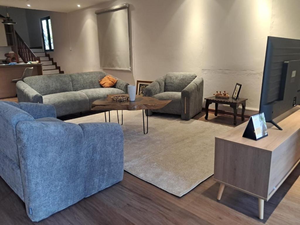 a living room with two couches and a tv at Villa Clair de Lagon in Blue Bay