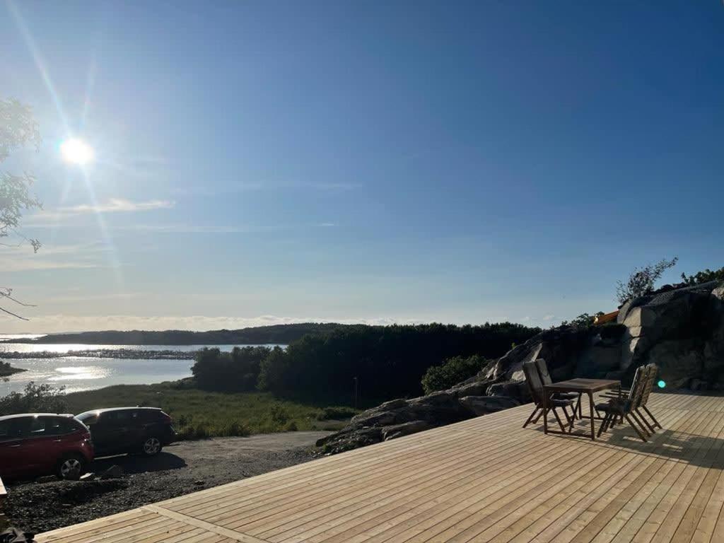 a deck with chairs and a view of a lake at Seaside panorama Villa with JETLESS hot tub in Gothenburg