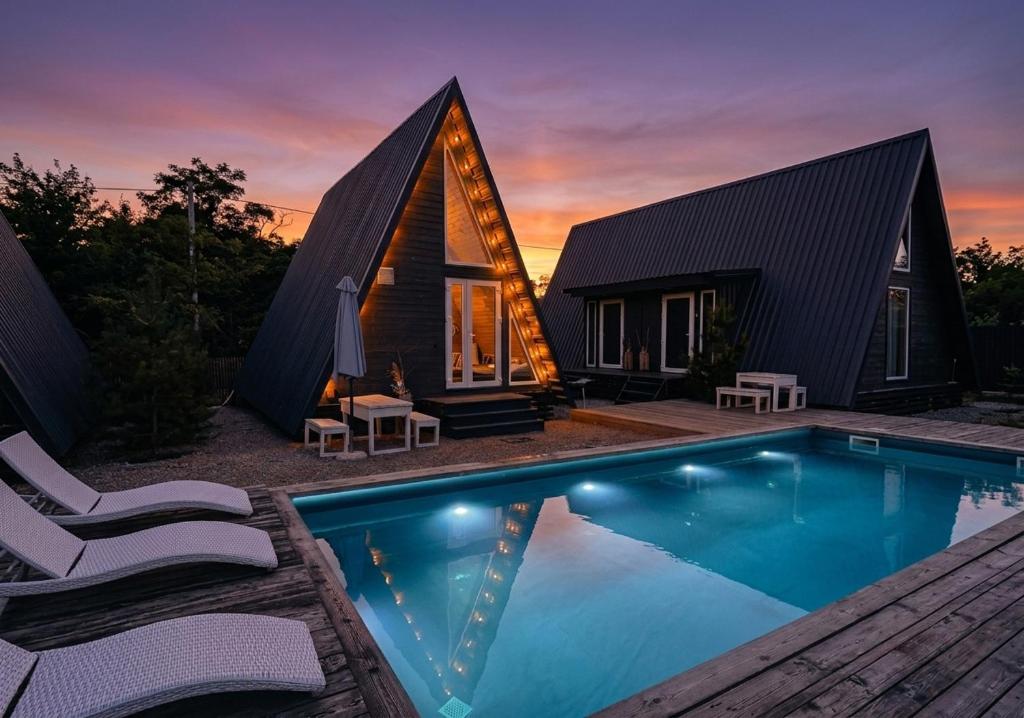 a house with a swimming pool in front of it at Долина ХЮГГЕ in Chornomors'ke