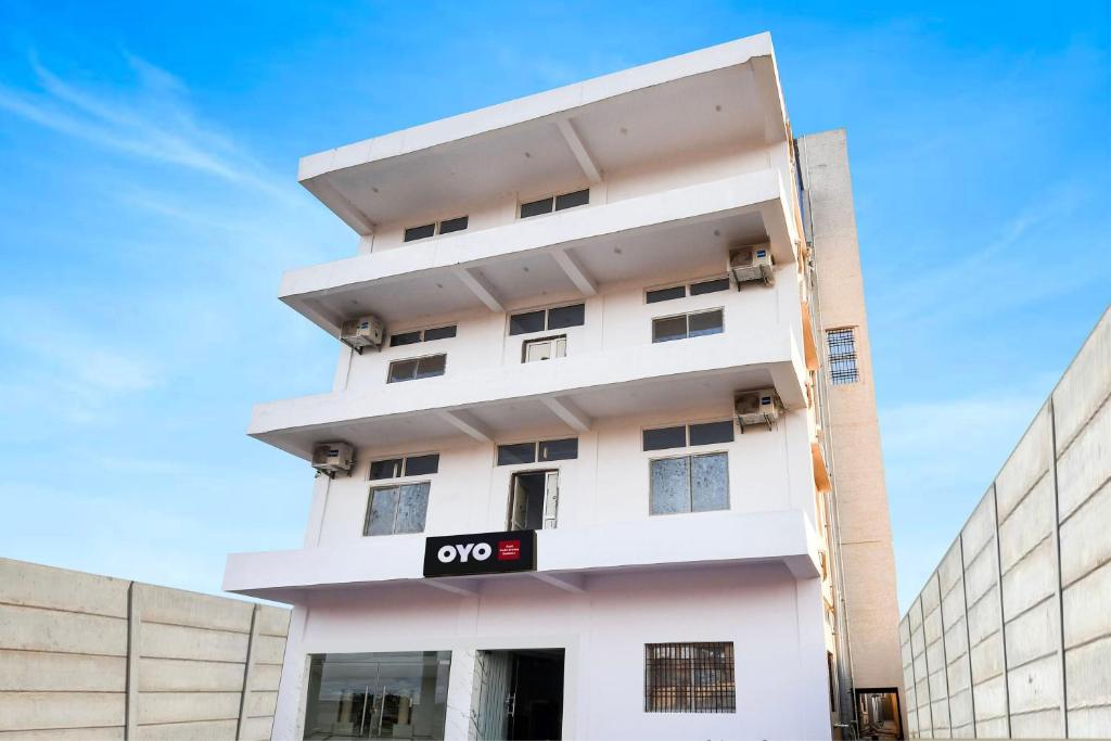 a white building with a qo sign on it at Hotel O Radha Krishna Residency in Nagri