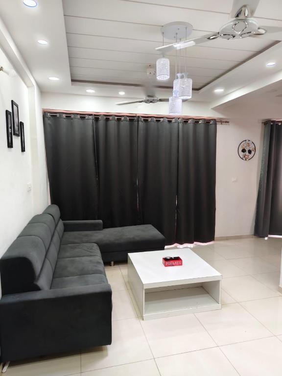 a living room with a couch and a table at 2bhk penthouse with open tarace in Vadodara