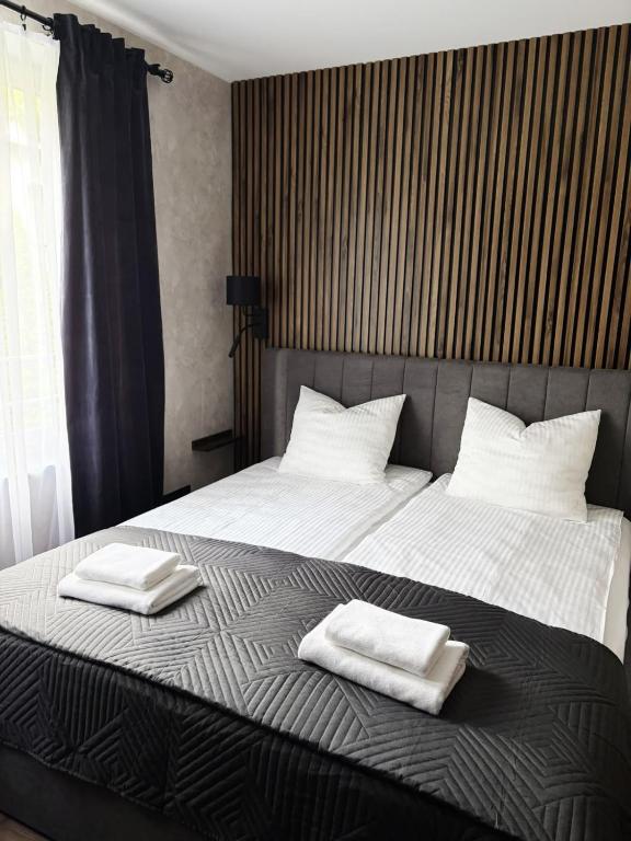 a bedroom with a bed with two towels on it at Edel Wellness Sleep & Spa in Gniezno