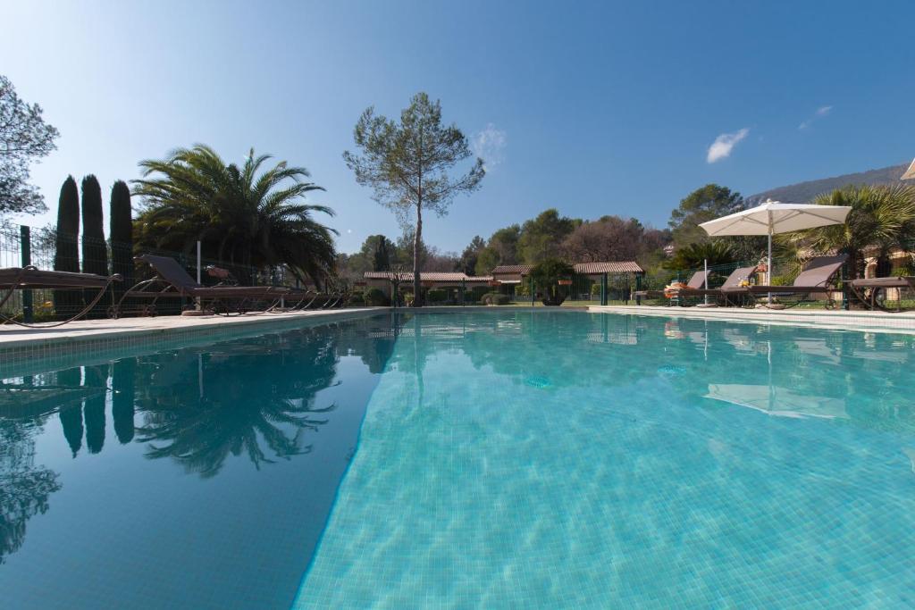 a large swimming pool with blue water at La Résidence du Moulin in Tourrettes-sur-Loup