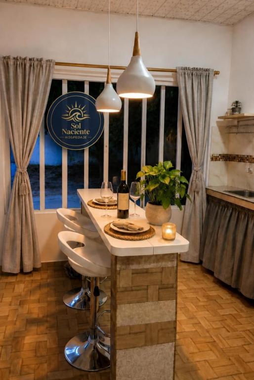 a kitchen with a table with chairs and a sign at Alojamiento Sol Naciente in Puerto Triunfo