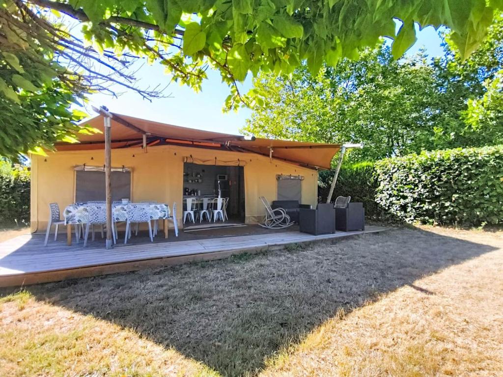a house with a table and chairs on a deck at Lodge La Vie Douce in Vigeois