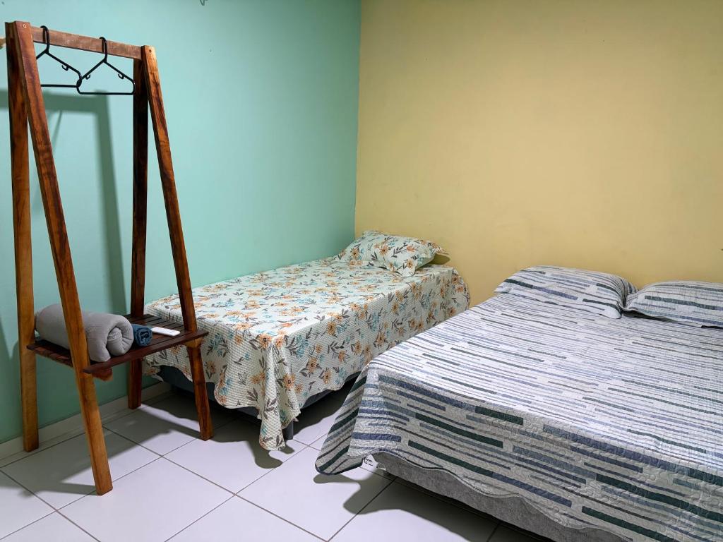 a bedroom with a bed and a mirror and a chair at Quarto Boto Tucuxi in Santarém