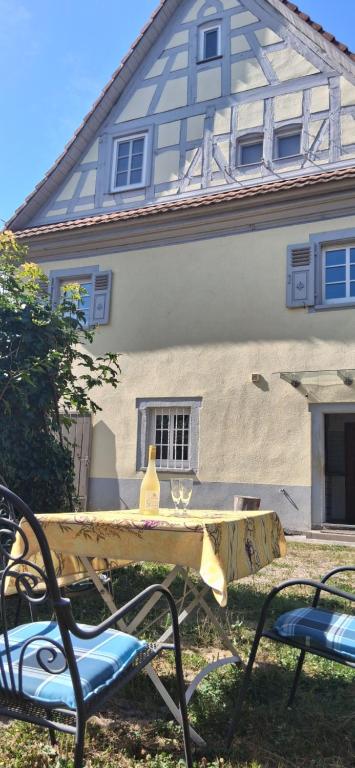 a table and two chairs in front of a house at Milchhäusle in Söllingen