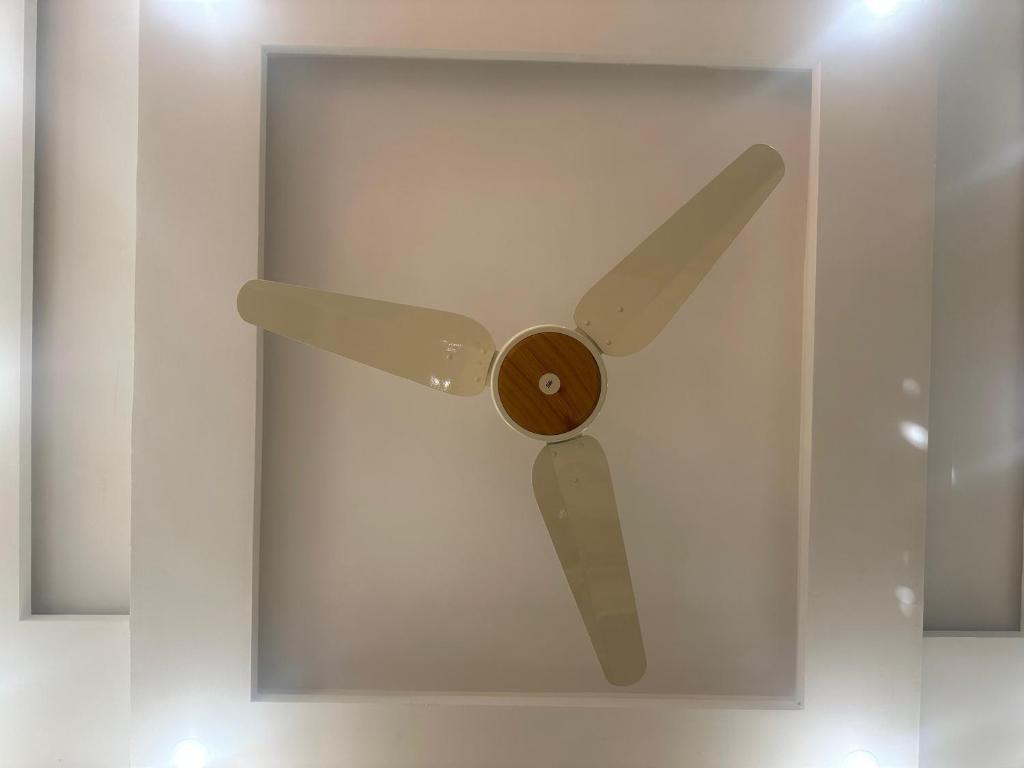 a wooden ceiling fan in a white wall at Premium 2 bed room apartment in Lahore
