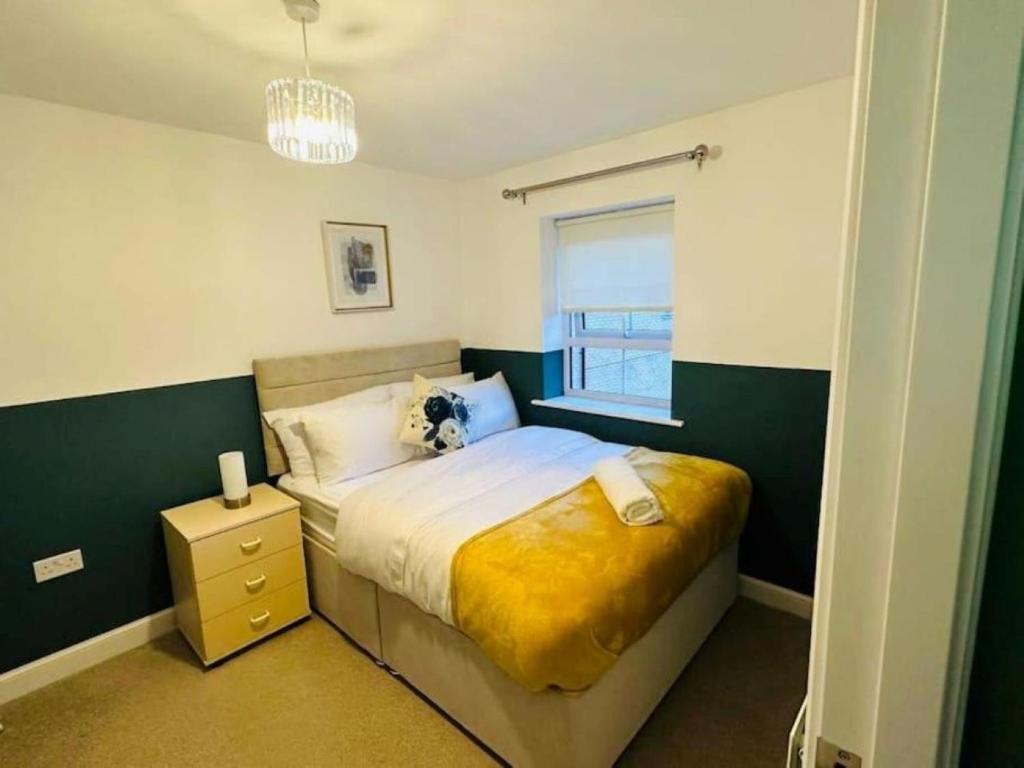 a bedroom with a bed with a yellow blanket and a window at Balne Mill Grove in Wakefield