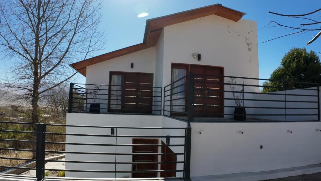 a small white building with a balcony at Cabañas Casa Blanca in El Mollar
