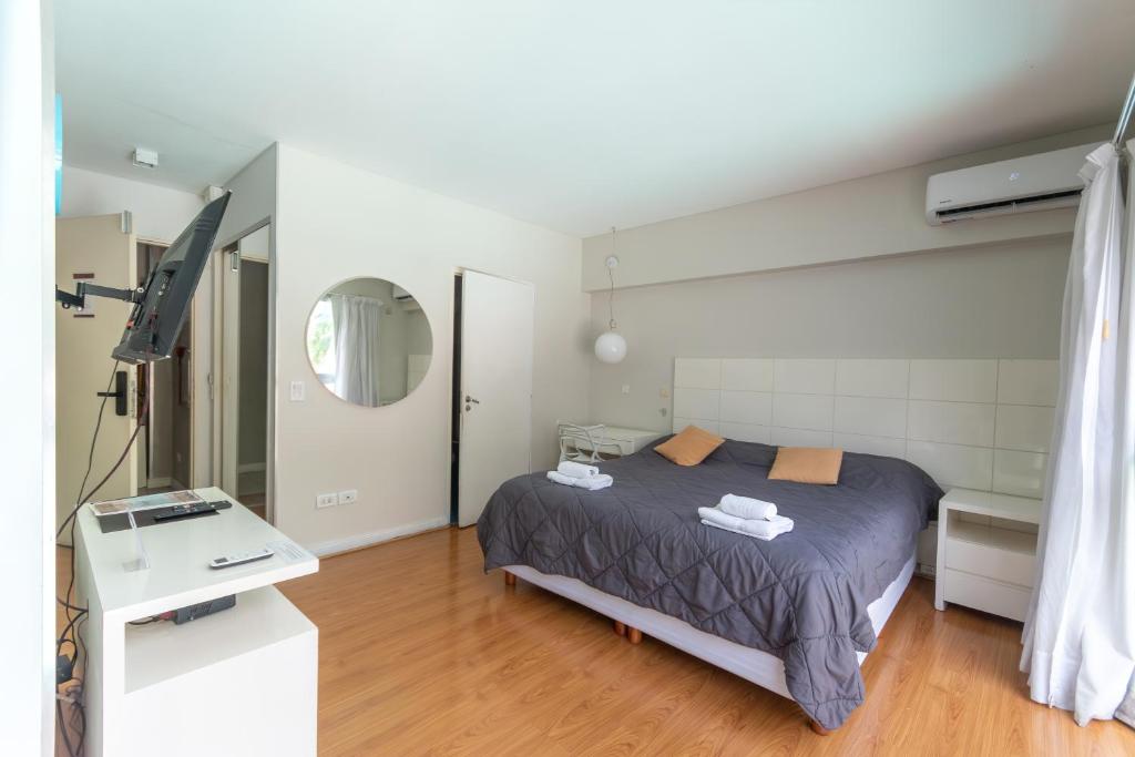 a bedroom with a bed and a mirror at Syrah Studios in Buenos Aires