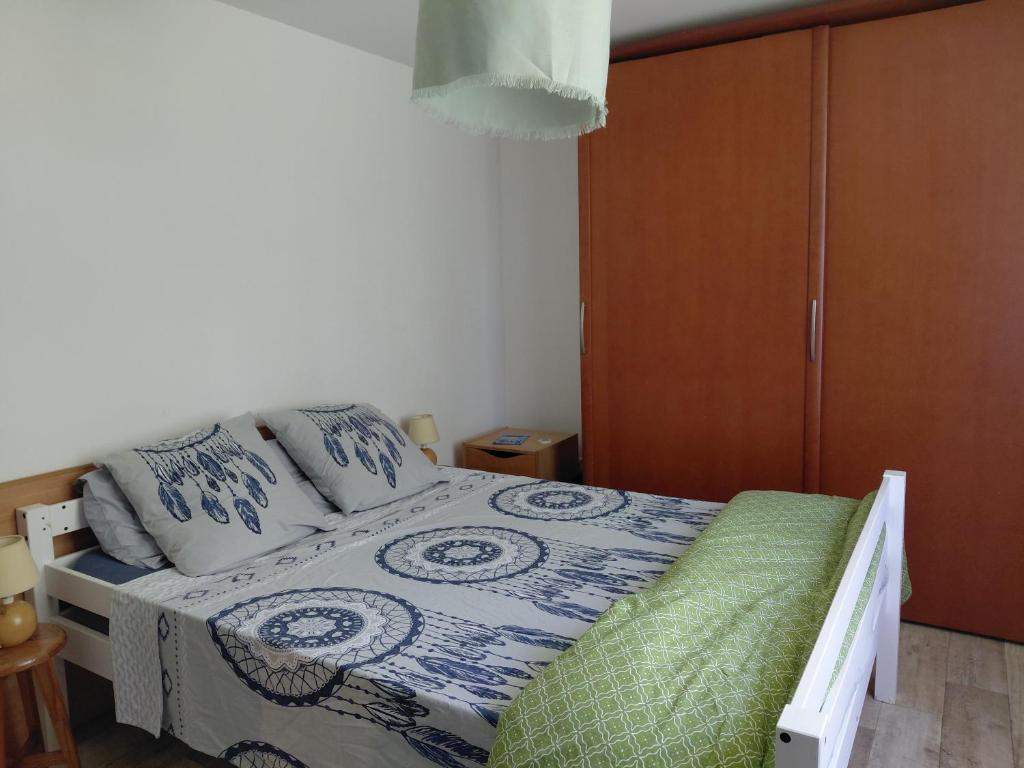a bedroom with a bed and a wooden cabinet at Chambre sous les toits in Baule