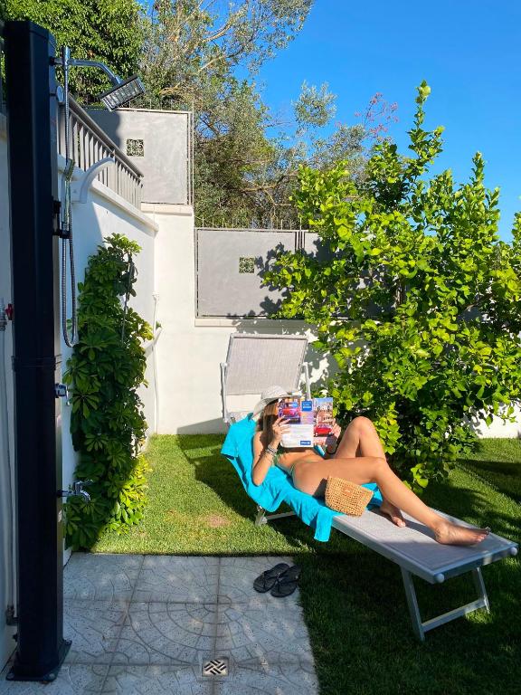 a woman laying on a chair in the grass at IL SOGNO luxury house in Santa Tecla