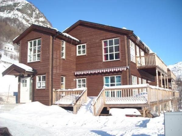 una gran casa de madera con nieve delante en Røldal Overnatting, en Røldal
